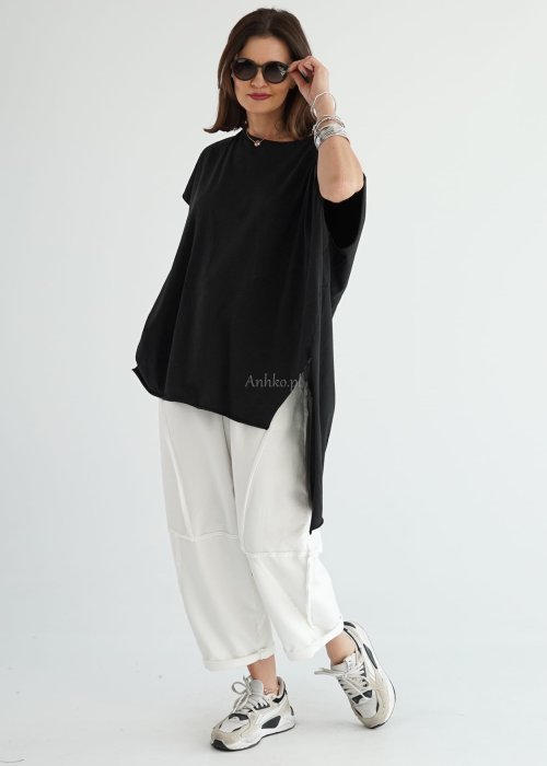 Czarna bluzka oversize z krótszym przodem, wydłużonym tyłem i bocznymi rozcięciami wykonana z miękkiej bawełny. Minimalistyczny model w nowoczesnej stylizacji
