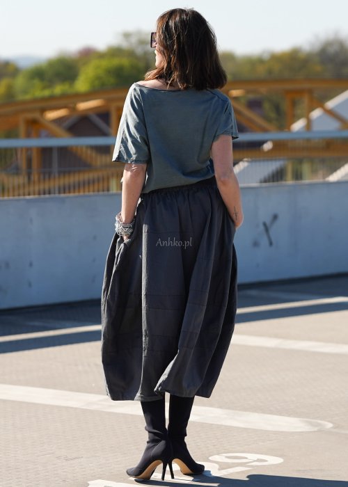 Grafitowa spódnica damska o kroju bombki z kieszeniami i dekoracyjnymi przeszyciami, pokazana w stylizacji z zielonym swetrem i czarnymi botkami na obcasie.