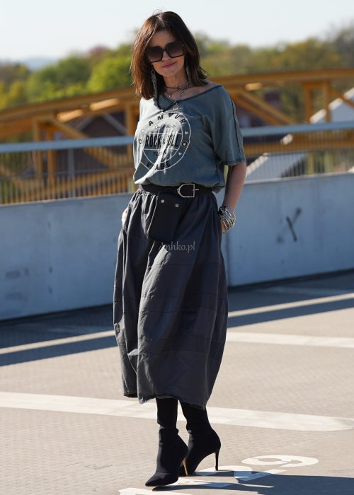 Grafitowa spódnica damska o kroju bombki z kieszeniami i dekoracyjnymi przeszyciami, pokazana w stylizacji z zielonym swetrem i czarnymi botkami na obcasie.