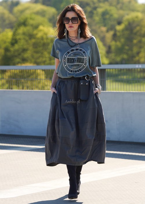 Grafitowa spódnica damska o kroju bombki z kieszeniami i dekoracyjnymi przeszyciami, pokazana w stylizacji z zielonym swetrem i czarnymi botkami na obcasie.