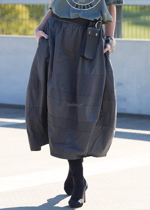 Grafitowa spódnica damska o kroju bombki z kieszeniami i dekoracyjnymi przeszyciami, pokazana w stylizacji z zielonym swetrem i czarnymi botkami na obcasie.