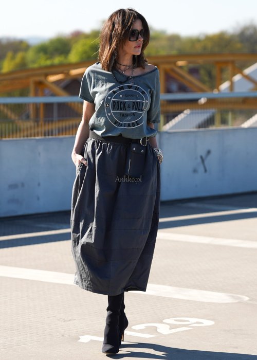 Grafitowa spódnica damska o kroju bombki z kieszeniami i dekoracyjnymi przeszyciami, pokazana w stylizacji z zielonym swetrem i czarnymi botkami na obcasie.