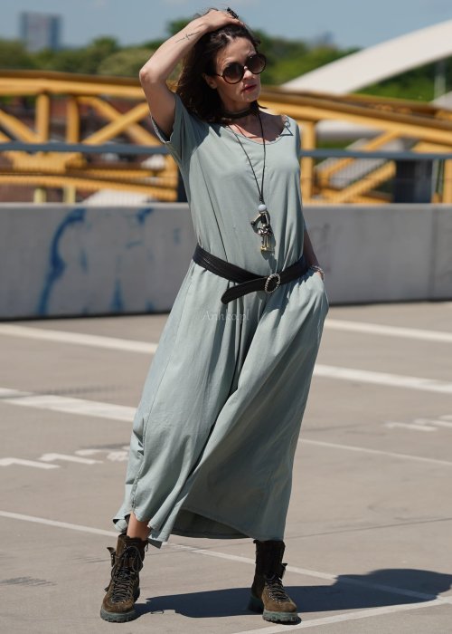 Kombinezon damski oversize w kolorze khaki z szerokimi nogawkami i wycięciem na plecach, stylizacja miejska z paskiem i biżuterią.