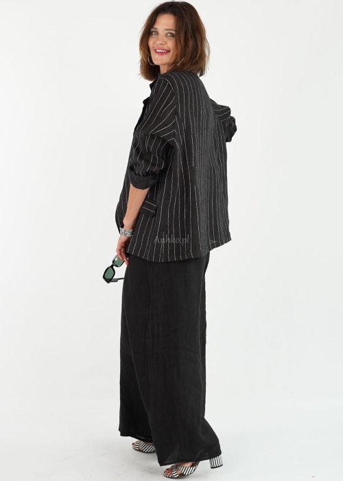 Czarne lniane spodnie damskie z bardzo szeroką nogawką i gumą w pasie, model z kieszeniami po bokach w swobodnej stylizacji.