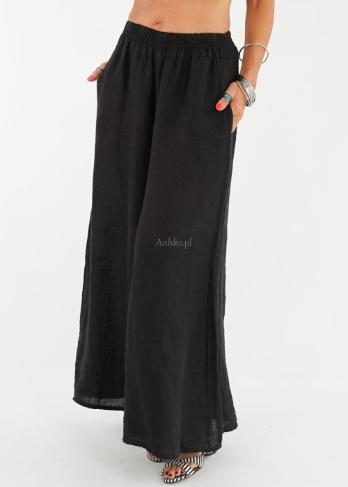 Czarne lniane spodnie damskie z bardzo szeroką nogawką i gumą w pasie, model z kieszeniami po bokach w swobodnej stylizacji.