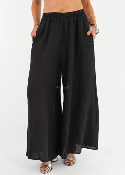 Czarne lniane spodnie damskie z bardzo szeroką nogawką i gumą w pasie, model z kieszeniami po bokach w swobodnej stylizacji.