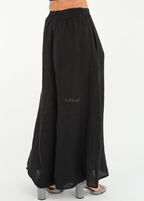 batch_DSC05956.jpgCzarne lniane spodnie damskie z bardzo szeroką nogawką i gumą w pasie, model z kieszeniami po bokach w swobodnej stylizacji.
