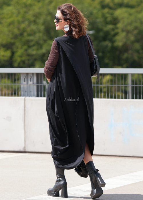 Czarna sukienka oversize o asymetrycznym kroju z zakładkami i rozcięciem, w stylizacji z płaskimi butami i dodatkami w miejskim, nowoczesnym wydaniu.