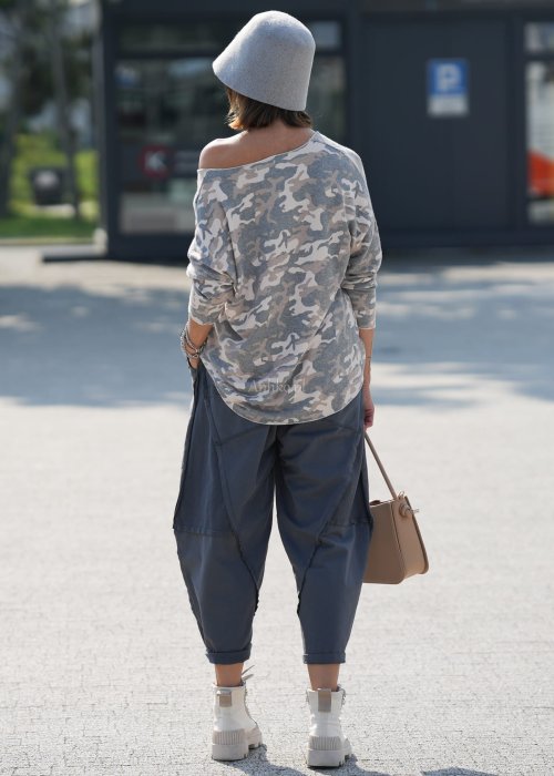 Szare spodnie damskie oversize z ozdobnymi przeszyciami i elastycznym pasem. Stylizacja z bluzką w print i jasnymi botkami w miejskim stylu.