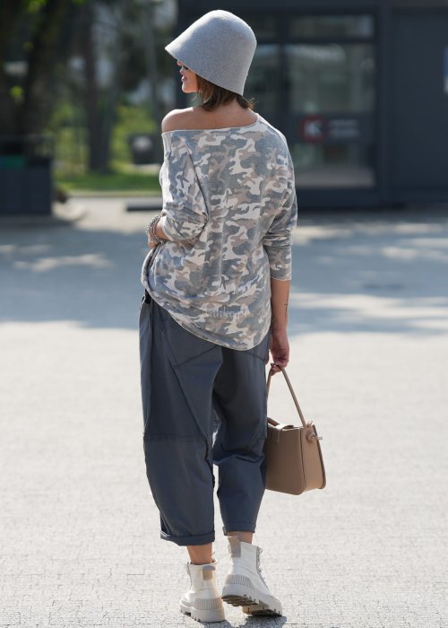 Szare spodnie damskie oversize z ozdobnymi przeszyciami i elastycznym pasem. Stylizacja z bluzką w print i jasnymi botkami w miejskim stylu.