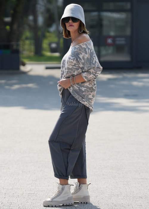 Szare spodnie damskie oversize z ozdobnymi przeszyciami i elastycznym pasem. Stylizacja z bluzką w print i jasnymi botkami w miejskim stylu.