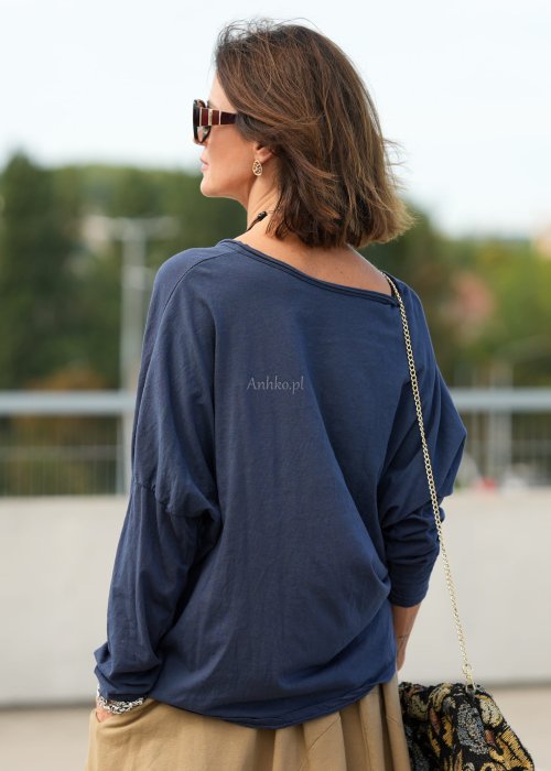 Granatowa bluzka oversize z dekoltem V i długim rękawem, luźno układająca się na sylwetce w stylizacji casual z szerokimi spodniami.