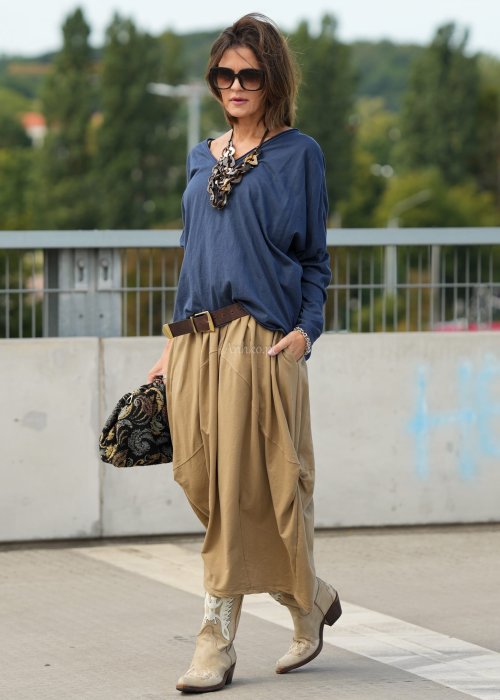 Granatowa bluzka oversize z dekoltem V i długim rękawem, luźno układająca się na sylwetce w stylizacji casual z szerokimi spodniami.