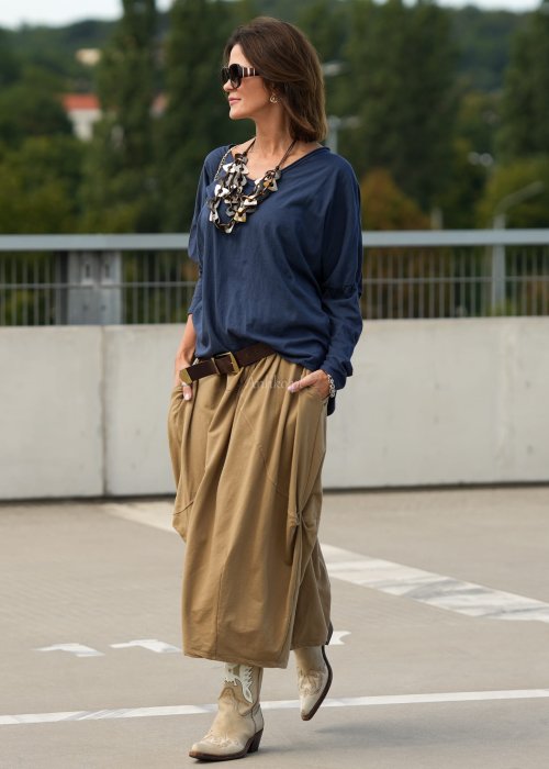 Granatowa bluzka oversize z dekoltem V i długim rękawem, luźno układająca się na sylwetce w stylizacji casual z szerokimi spodniami.