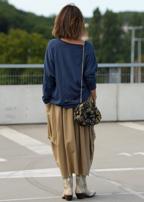 Granatowa bluzka oversize z dekoltem V i długim rękawem, luźno układająca się na sylwetce w stylizacji casual z szerokimi spodniami.