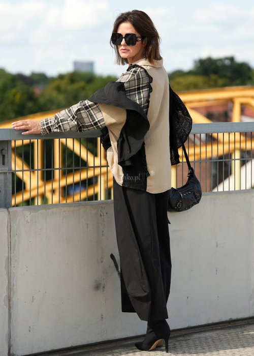 Czarne spodnie damskie z szeroką nogawką i efektem bombki, z elastycznym pasem. Stylizacja z botkami na obcasie w nowoczesnym, miejskim stylu.