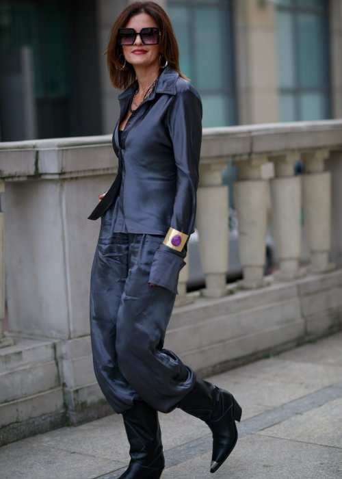 Elegancka bluzka koszulowa o dopasowanym, kobiecym kroju, wyraźnie modelującym talię. Wykonana z gładkiej, lejącej tkaniny o satynowym połysku