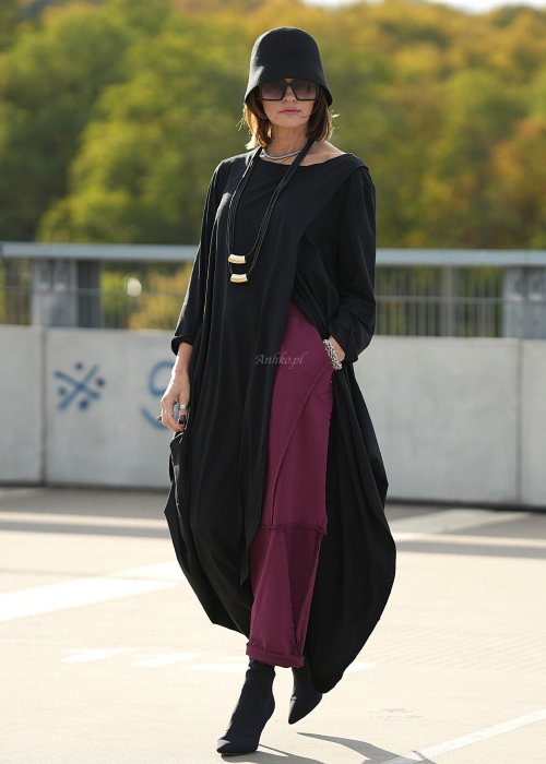 Bordowe spodnie dresowe damskie z obniżonym krokiem i ozdobnymi przeszyciami, luźny fason z gumką w pasie i sznurkiem, stylizacja miejska z czarnymi botkami.