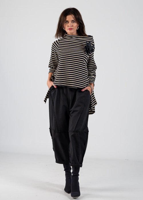 Czarne spodnie dresowe damskie o luźnym kroju baggy z ozdobnymi przeszyciami i gumką w pasie, stylizowane ze sneakersami w miejskim looku.