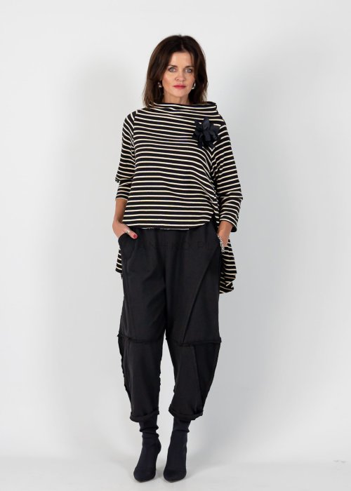 Czarne spodnie dresowe damskie o luźnym kroju baggy z ozdobnymi przeszyciami i gumką w pasie, stylizowane ze sneakersami w miejskim looku.