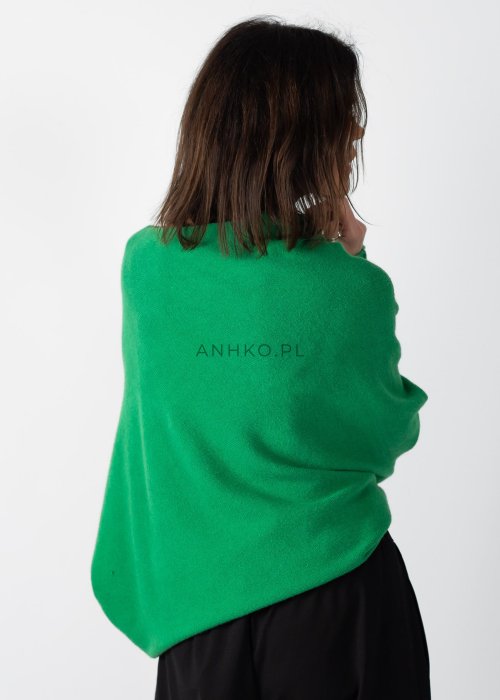 Zielony sweter damski oversize o nietoperzowym kroju z asymetrycznym dołem, stylizacja z czarną spódnicą.