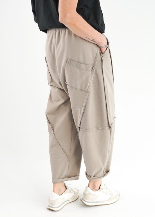 Beżowe spodnie oversize z obniżonym krokiem i dekoracyjnymi przeszyciami, luźny fason, miejska stylizacja damska.