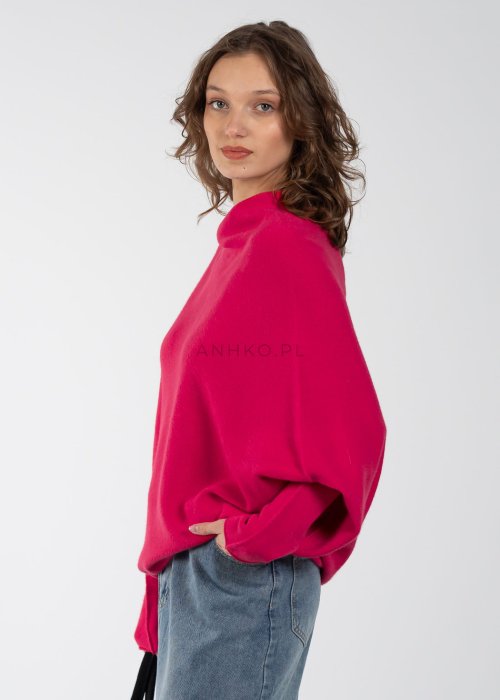 Różowy sweter oversize o nietoperzowym kroju z dekoltem łódka, asymetryczny dół, stylizacja z jeansową spódnicą.