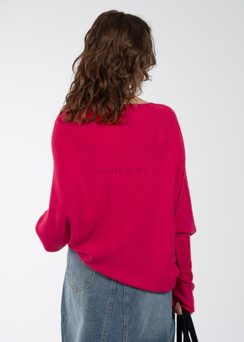 Różowy sweter oversize o nietoperzowym kroju z dekoltem łódka, asymetryczny dół, stylizacja z jeansową spódnicą.
