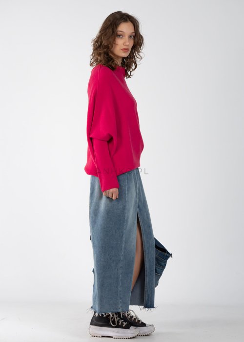 Różowy sweter oversize o nietoperzowym kroju z dekoltem łódka, asymetryczny dół, stylizacja z jeansową spódnicą.