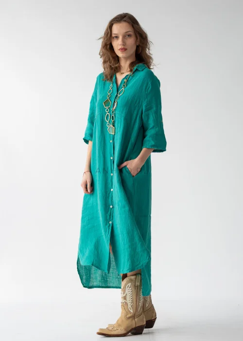Turkusowa sukienka maxi lniana w stylu szmizjerki, zapinana na guziki, z kołnierzykiem i luźnym fasonem, zestawiona z kowbojkami.
