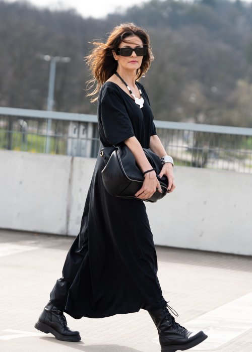 Czarny kombinezon damski oversize z szerokimi nogawkami i krótkim rękawem, minimalistyczna stylizacja miejska z biżuterią.