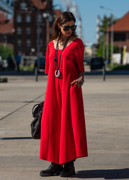 Czerwony kombinezon oversize z krótkim rękawem i szeroką nogawką, stylizacja miejska z czarnymi dodatkami i dużą torbą.