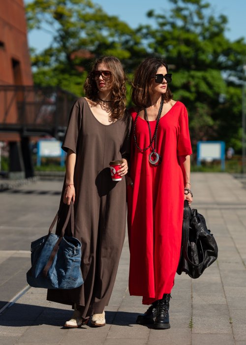 Czerwony kombinezon oversize z krótkim rękawem i szeroką nogawką, stylizacja miejska z czarnymi dodatkami i dużą torbą.