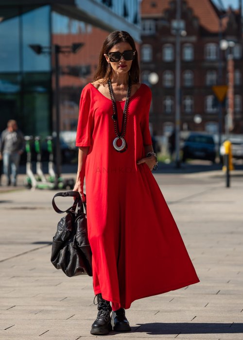 Czerwony kombinezon oversize z krótkim rękawem i szeroką nogawką, stylizacja miejska z czarnymi dodatkami i dużą torbą.