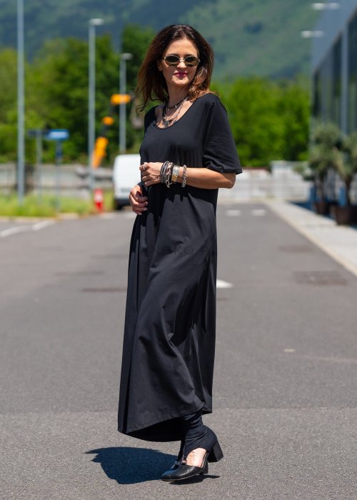 Czarny kombinezon damski oversize z szerokimi nogawkami i krótkim rękawem, minimalistyczna stylizacja miejska z biżuterią.