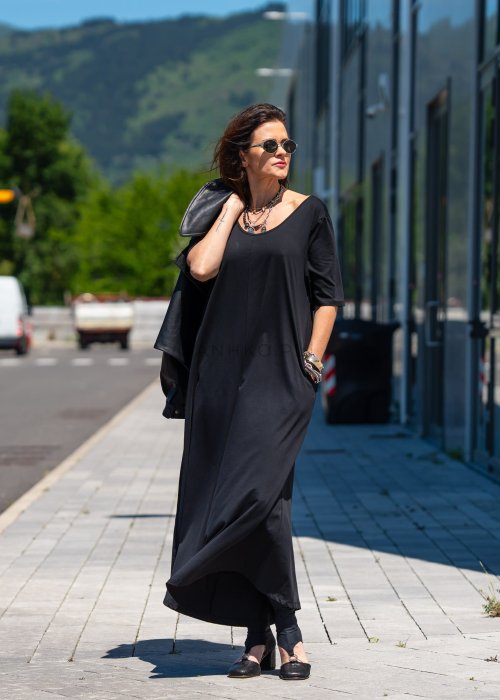 Czarny kombinezon damski oversize z szerokimi nogawkami i krótkim rękawem, minimalistyczna stylizacja miejska z biżuterią.