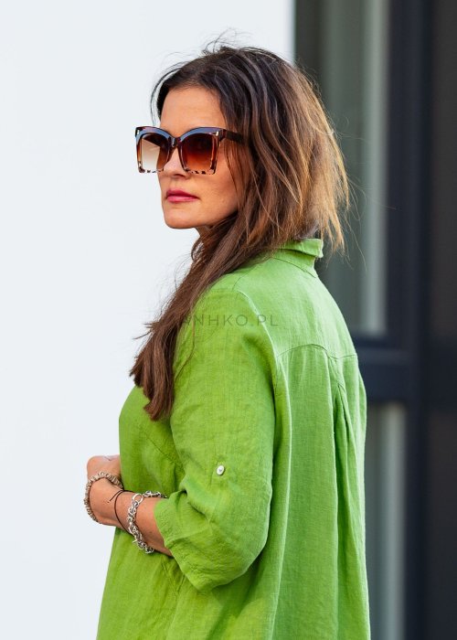 Jasnozielona lniana sukienka maxi w stylu szmizjerki, zapinana na guziki, o luźnym fasonie oversize, stylizowana z kowbojkami i dużą torbą.