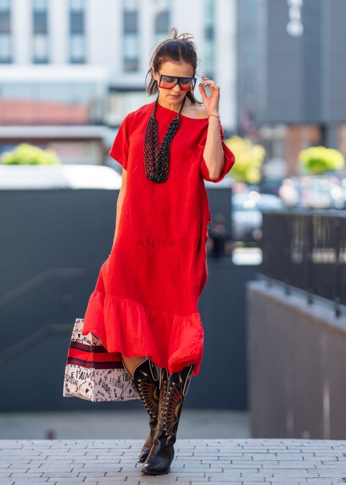 Czerwona lniana sukienka midi z krótkim rękawem i kokardą na plecach, stylizacja z kozakami i dużą torbą w miejskim stylu.