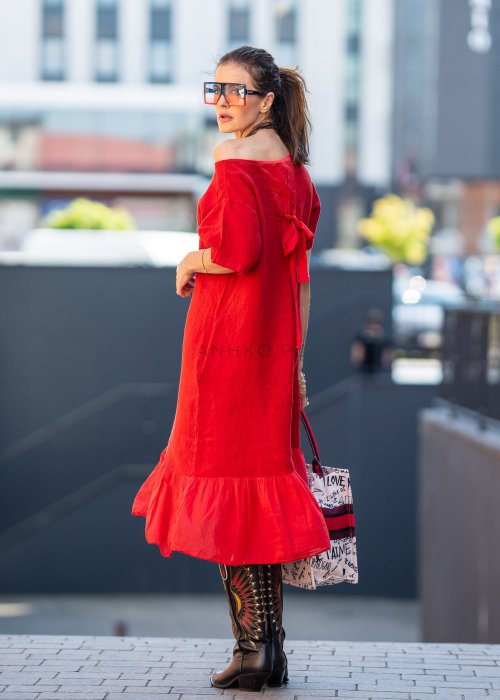 Czerwona lniana sukienka midi z krótkim rękawem i kokardą na plecach, stylizacja z kozakami i dużą torbą w miejskim stylu.