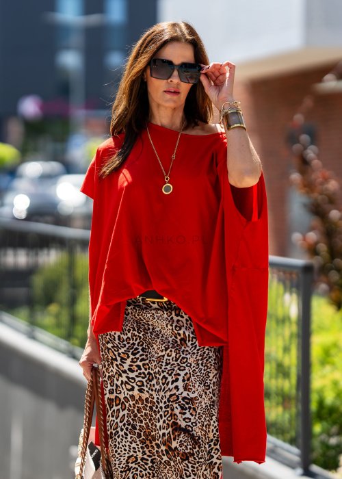 Czerwona bluzka oversize z asymetrycznym dołem i wydłużonym tyłem, zestawiona ze wzorzystą spódnicą. Luźny fason tworzy wyrazistą stylizację.