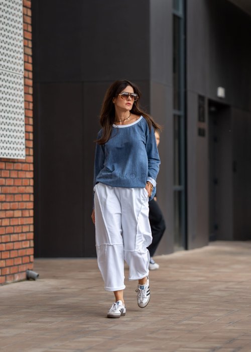 Niebieska bluza oversize w odcieniu denimu z białym ściągaczem przy dekolcie, luźny fason, miejska stylizacja damska.