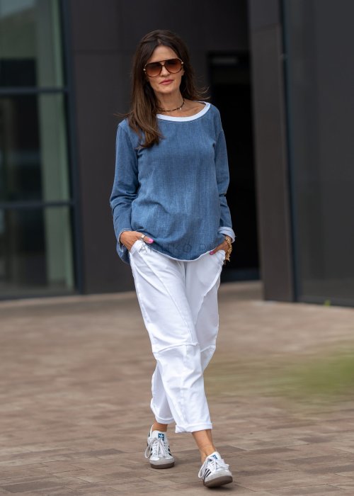Niebieska bluza oversize w odcieniu denimu z białym ściągaczem przy dekolcie, luźny fason, miejska stylizacja damska.