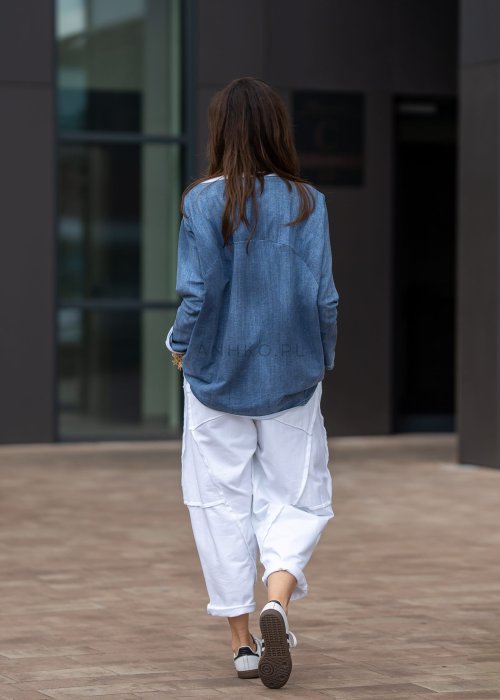 Białe spodnie oversize z obniżonym krokiem i dekoracyjnymi przeszyciami, luźny fason, nowoczesna stylizacja damska.