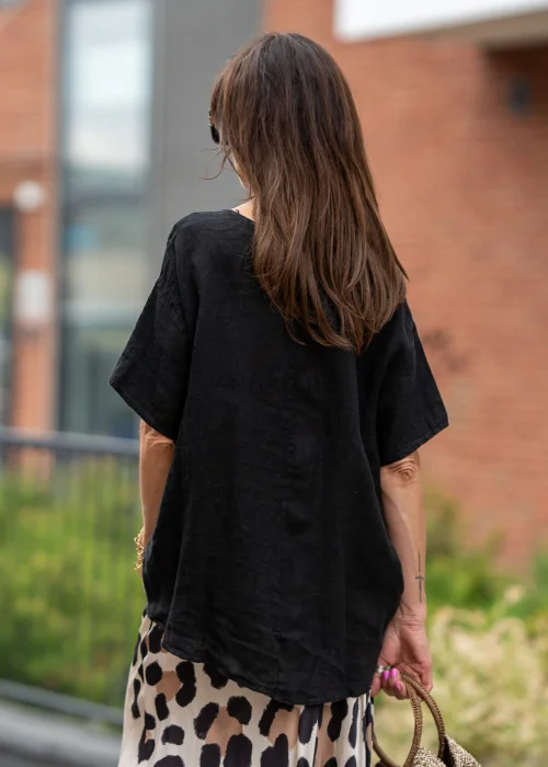 Czarna bluzka lniana oversize z krótkim rękawem i ozdobnym ściągaczem z przodu. Naturalny model z lnu w minimalistycznej, eleganckiej stylizacji.