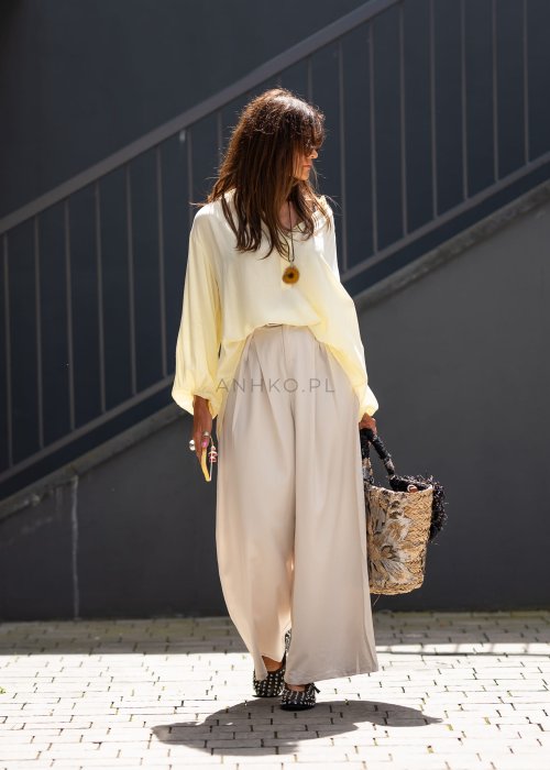 Kremowe spodnie damskie z szeroką nogawką i wysokim stanem, elegancki model z paskiem w talii.