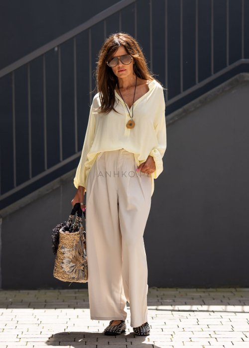 Kremowe spodnie damskie z szeroką nogawką i wysokim stanem, elegancki model z paskiem w talii.