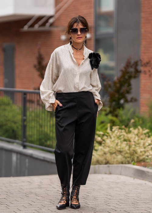 Czarne spodnie damskie typu cygaretki z elastycznym pasem i zwężaną nogawką, zestawione z botkami w eleganckiej miejskiej stylizacji.