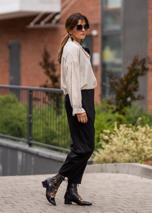 Czarne spodnie damskie typu cygaretki z elastycznym pasem i zwężaną nogawką, zestawione z botkami w eleganckiej miejskiej stylizacji.