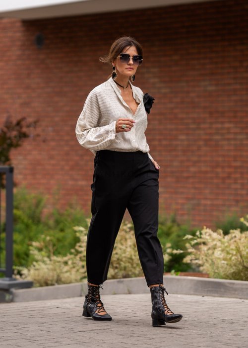 Czarne spodnie damskie typu cygaretki z elastycznym pasem i zwężaną nogawką, zestawione z botkami w eleganckiej miejskiej stylizacji.
