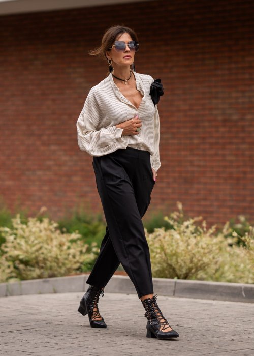 Czarne spodnie damskie typu cygaretki z elastycznym pasem i zwężaną nogawką, zestawione z botkami w eleganckiej miejskiej stylizacji.